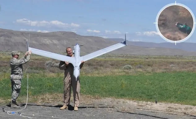Photo of two men holding an Insitu uncrewed air vehicle